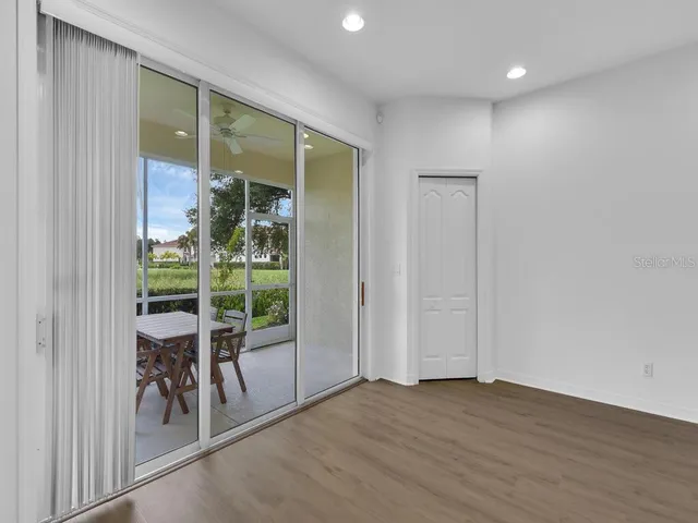 an empty room with sliding door and wooden floor