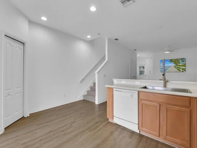 a kitchen with a sink and wooden floor