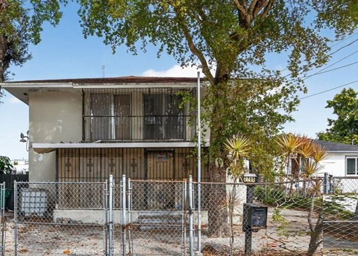 a front view of a house with a tree