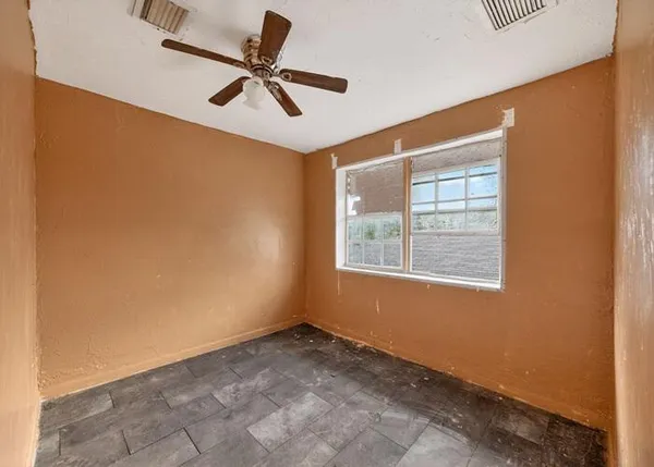 a view of empty room with wooden floor and ceiling fan