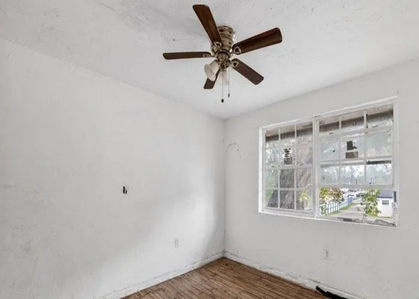 a view of a livingroom with a ceiling fan & windows