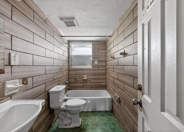 a bathroom with a toilet a sink and shower