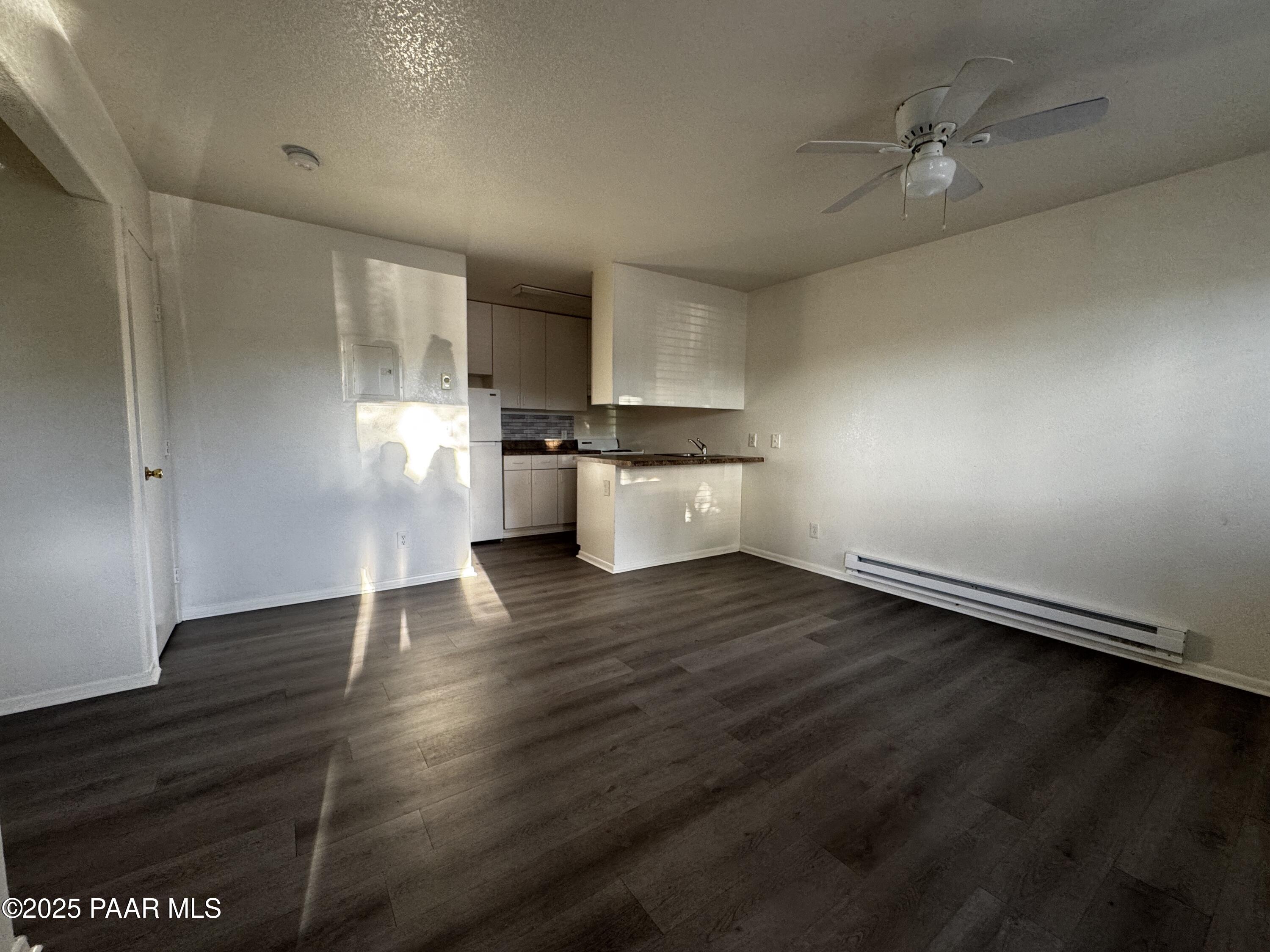 4873 North Judy Court, Unit B Prescott Valley, AZ 86314 - Photo 3 of 6 an empty room with wooden floor and stainless steel appliances