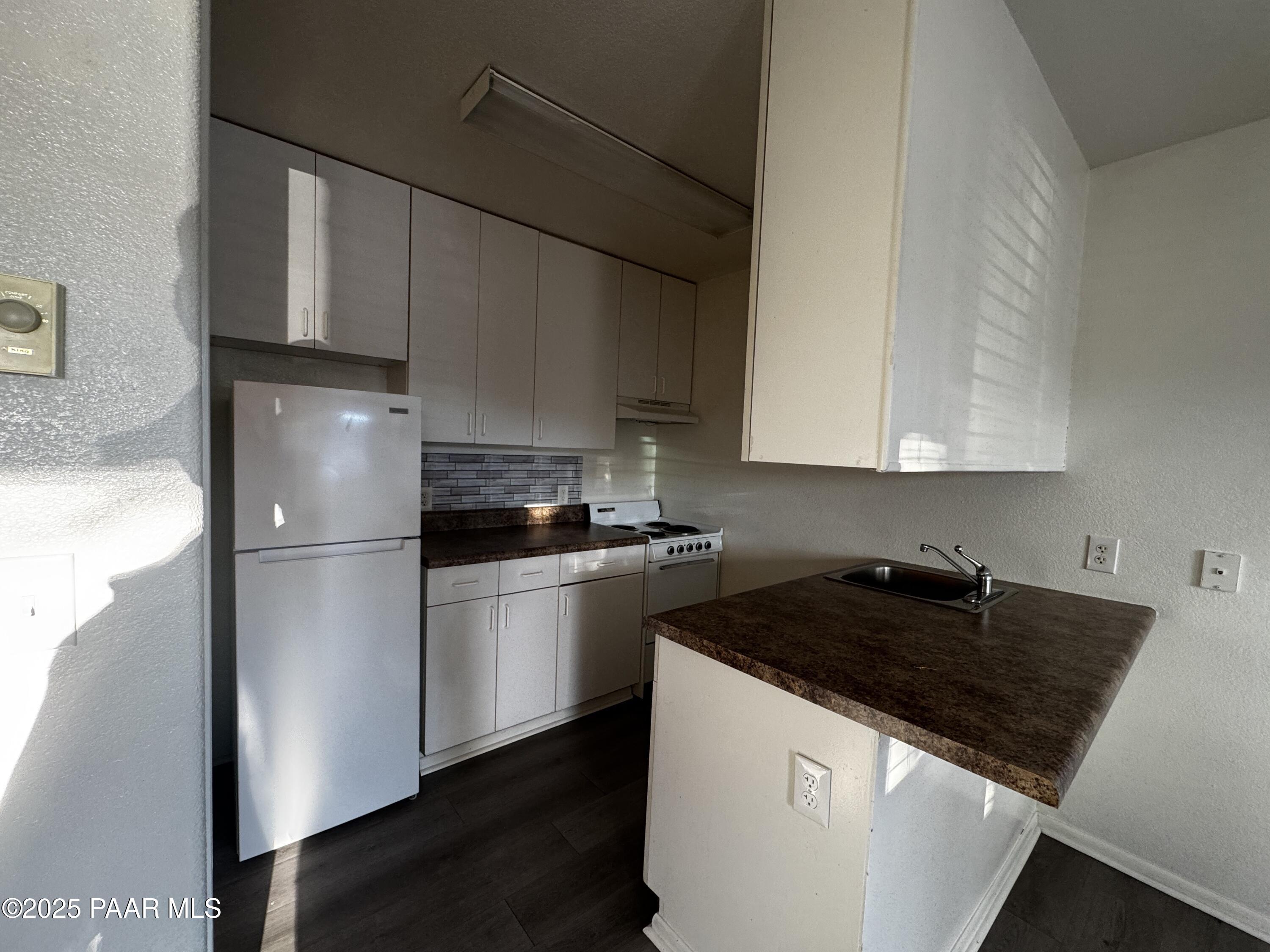 4873 North Judy Court, Unit B Prescott Valley, AZ 86314 - Photo 5 of 6 a kitchen with a refrigerator and a sink