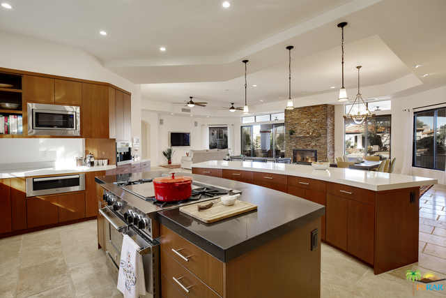 a kitchen with granite countertop a stove a sink dishwasher and a refrigerator with wooden floor