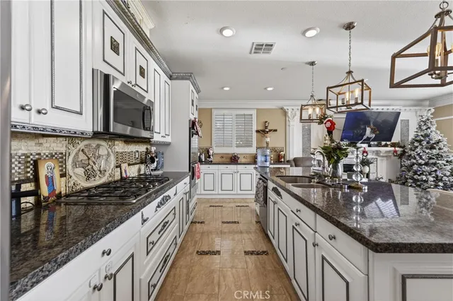 a kitchen with stainless steel appliances granite countertop a sink stove and cabinets