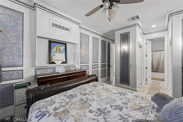 a bedroom with a bed dresser and floor to ceiling window