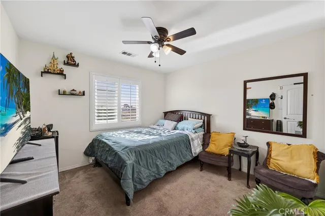 a bedroom with a bed and ceiling fan