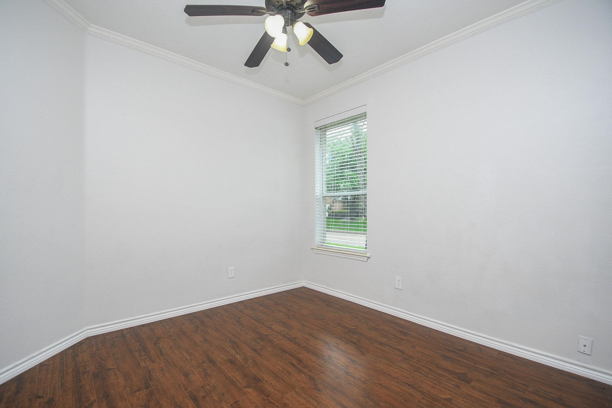 5602 Walkabout Way Katy, TX 77450 - Photo 25 of 33 an empty room with wooden floor chandelier fan and windows