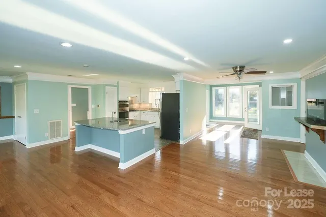 a large living room with stainless steel appliances granite countertop a couch and a fireplace