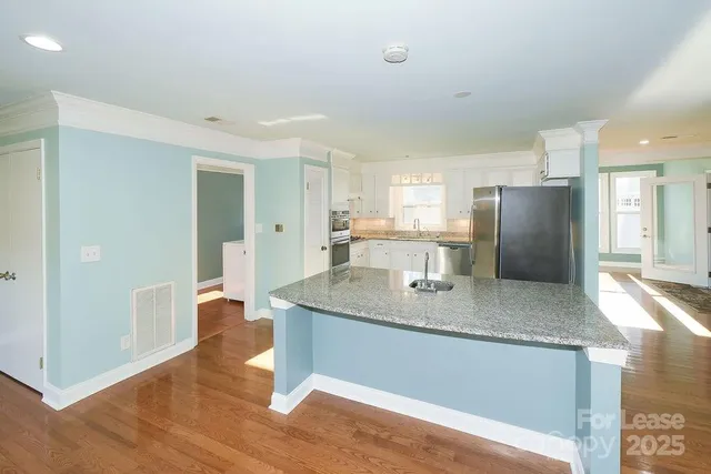 a kitchen with stainless steel appliances granite countertop a sink refrigerator and cabinets