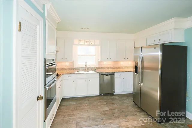 a kitchen with a refrigerator sink and cabinets