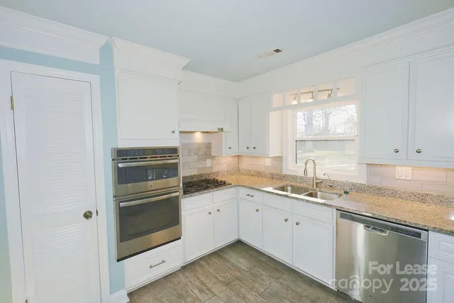 a kitchen with a sink and stainless steel appliances