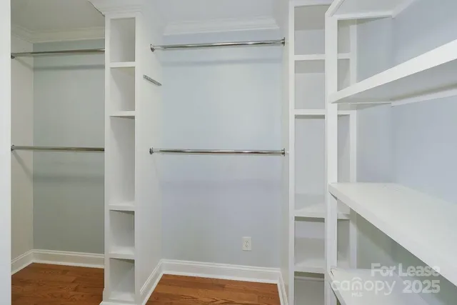 a view of walk in closet with empty racks
