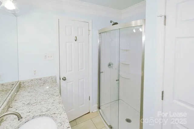 a bathroom with a granite countertop shower mirror and a sink