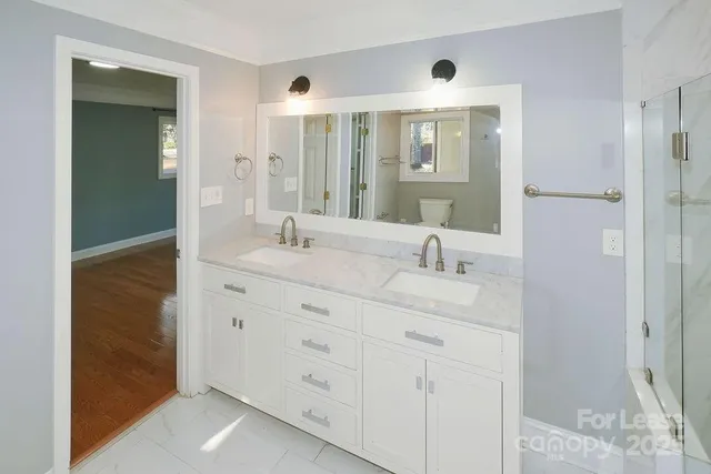 a bathroom with double sink and a mirror