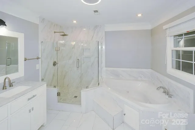 a spacious bathroom with a tub sink a shower and a mirror