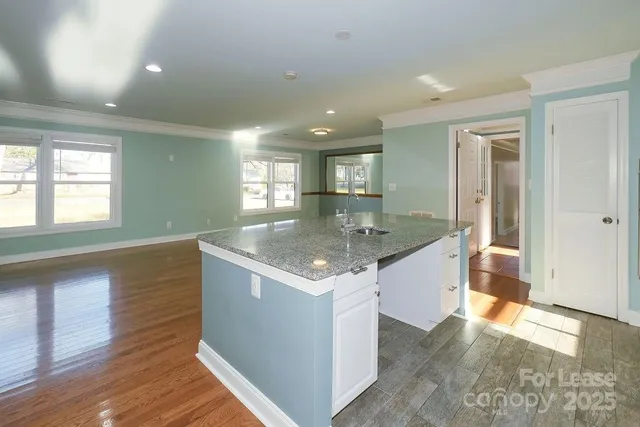 an open kitchen with granite countertop a sink and a stove top oven