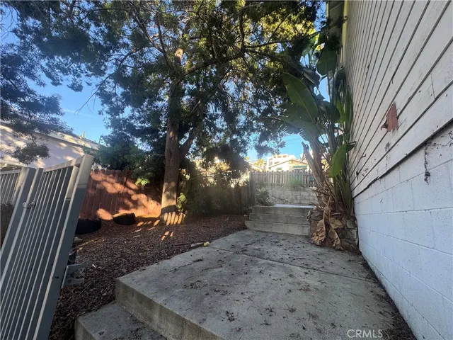 a view of a backyard with wooden fence