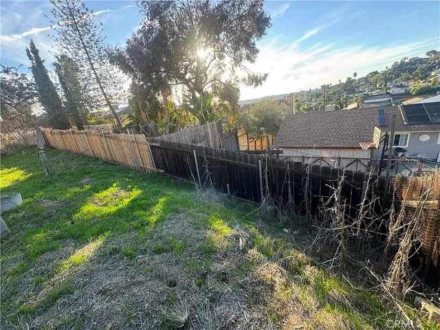 a view of a yard with plants and a fountain