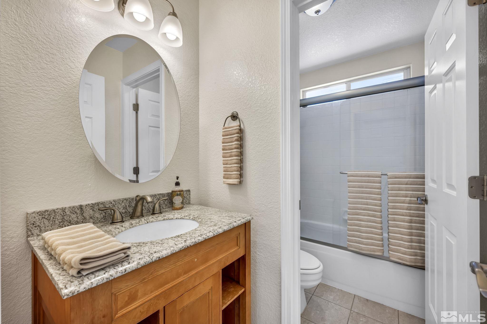 7491 Wheeldale Circle Reno, NV 89511 - Photo 27 of 33 a bathroom with a granite countertop sink toilet and shower