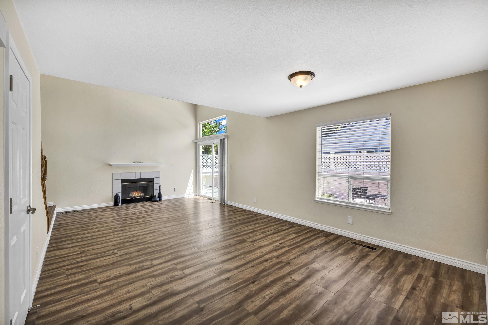 7491 Wheeldale Circle Reno, NV 89511 - Photo 5 of 33 a view of a livingroom with wooden floor fireplace and windows