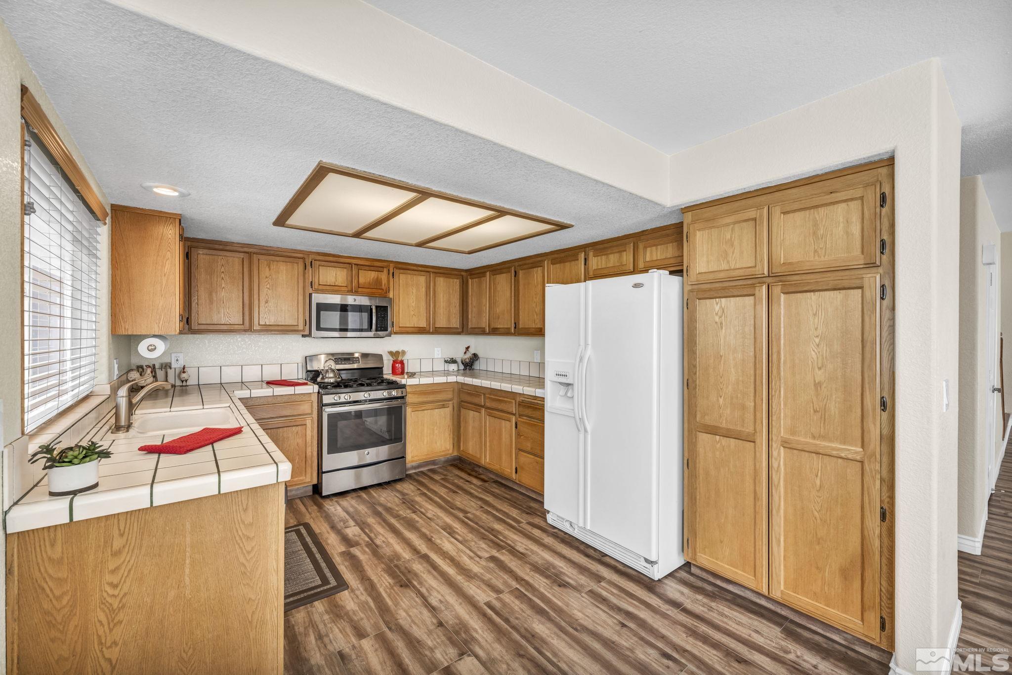 7491 Wheeldale Circle Reno, NV 89511 - Photo 7 of 33 a kitchen that has a lot of cabinets a sink and appliances in it