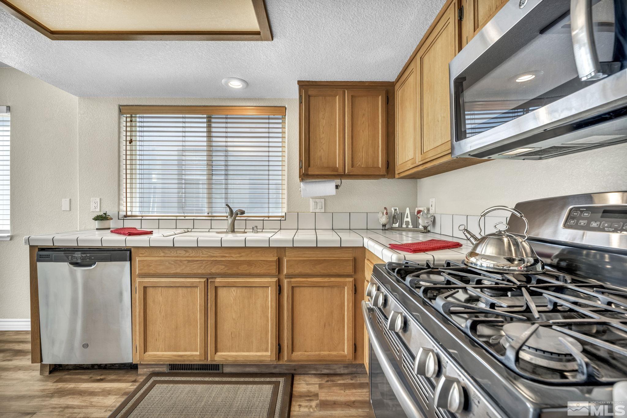 7491 Wheeldale Circle Reno, NV 89511 - Photo 8 of 33 a kitchen with a sink a stove and cabinets