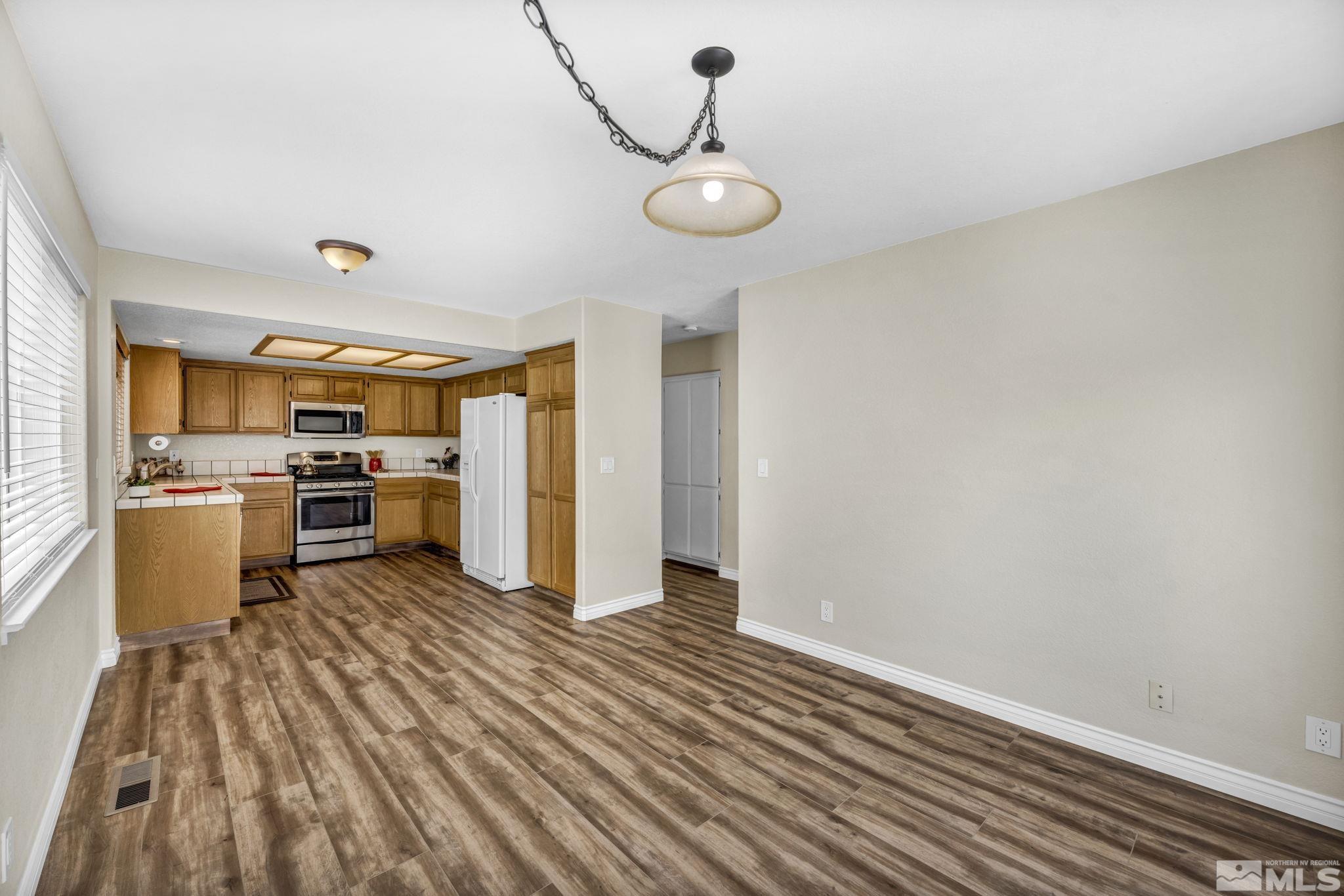 7491 Wheeldale Circle Reno, NV 89511 - Photo 9 of 33 a view of a kitchen with wooden floor and stainless steel appliances