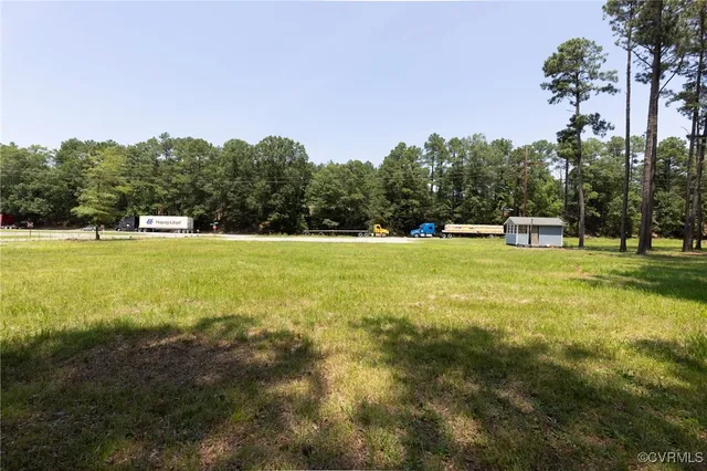 a view of a large pool with lawn chairs under an umbrella