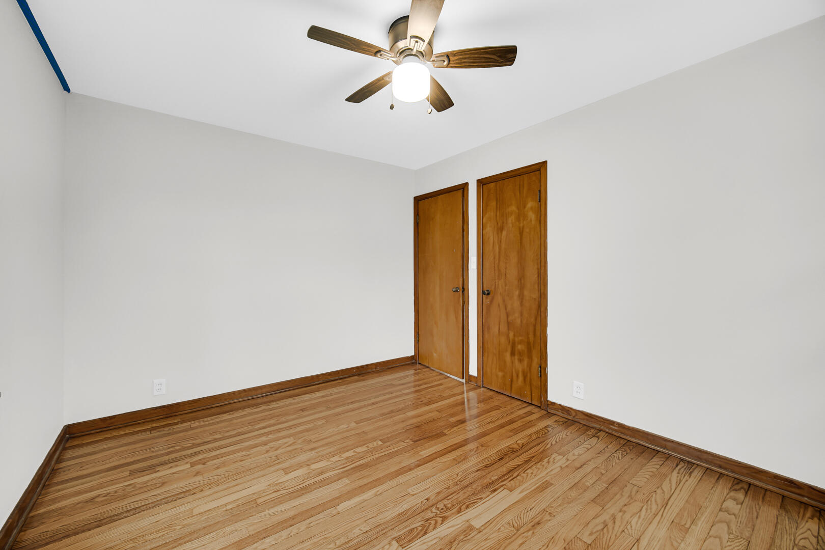 602 Ohio Street Walkerton, IN 46574 - Photo 10 of 31 an empty room with wooden floor and a ceiling fan