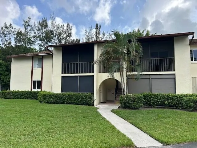 a view of a house with brick walls and a yard with plants