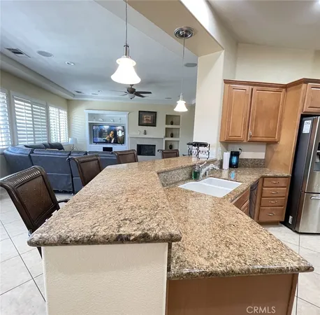 a large kitchen with granite countertop a sink a counter top space appliances and a window