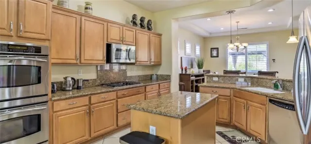 a kitchen with stainless steel appliances granite countertop a sink a stove and cabinets