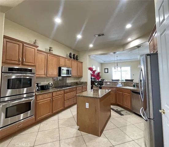 a kitchen with granite countertop a sink stainless steel appliances and cabinets