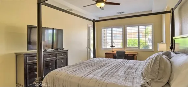 a bedroom with a bed dresser and a large window