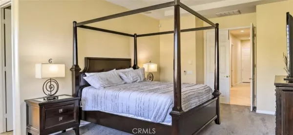 a bedroom with a bed a mirror and a desk