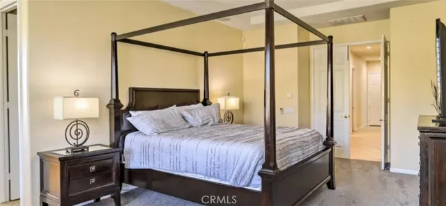 a bedroom with a bed a mirror and a desk