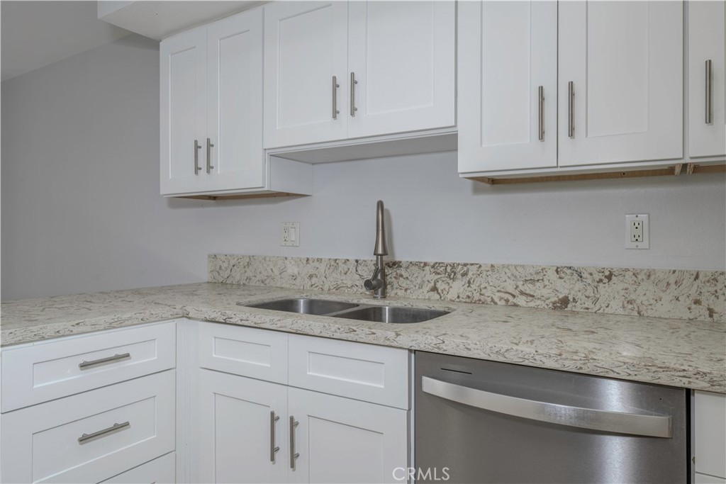 12660 Briarglen Loop, Unit G Stanton, CA 90680 - Photo 12 of 38 a kitchen with granite countertop white cabinets and a sink