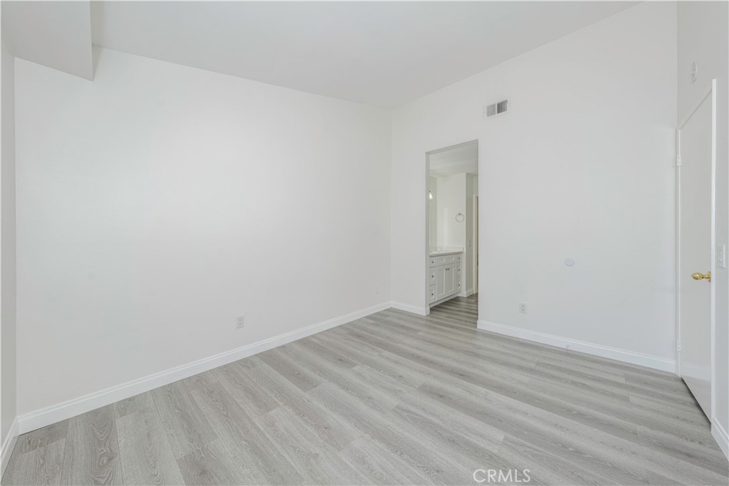 12660 Briarglen Loop, Unit G Stanton, CA 90680 - Photo 18 of 38 a view of an empty room with wooden floor and a window