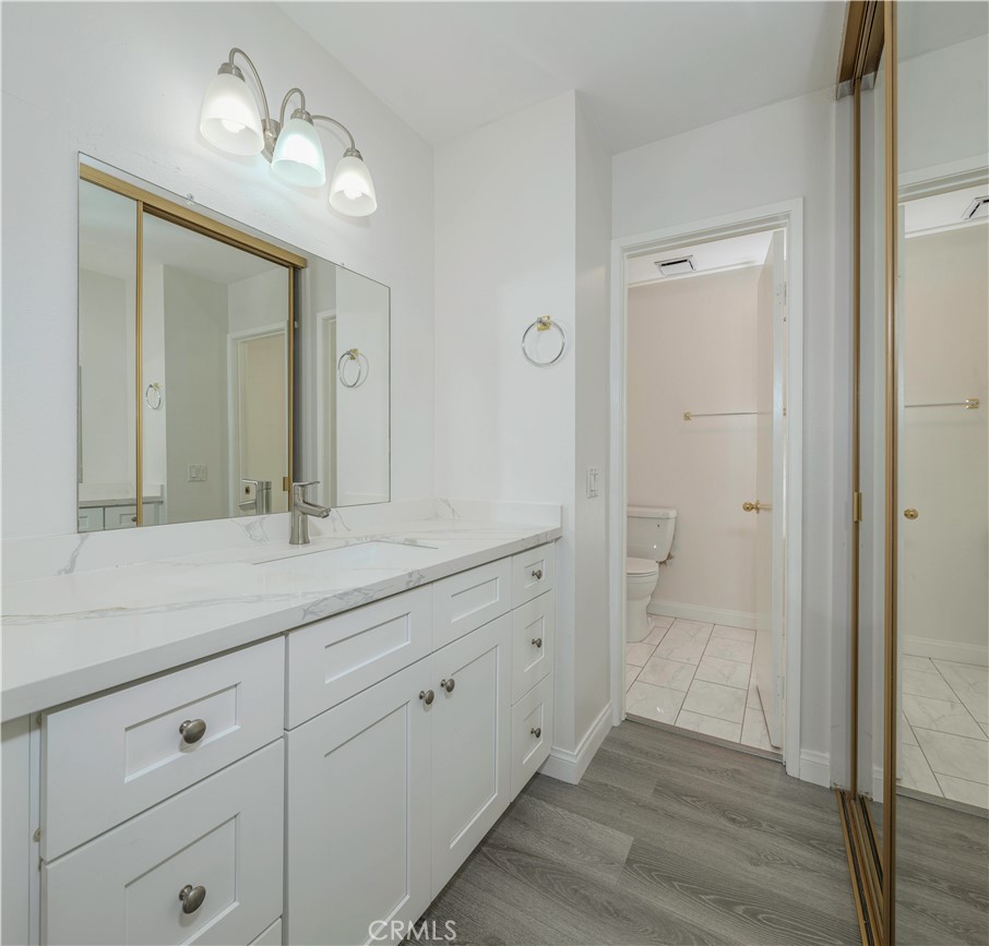 12660 Briarglen Loop, Unit G Stanton, CA 90680 - Photo 19 of 38 a bathroom with a granite countertop sink mirror and shower