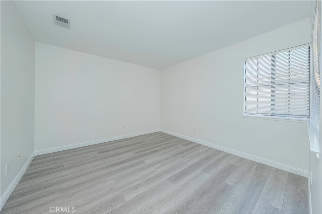 12660 Briarglen Loop, Unit G Stanton, CA 90680 - Photo 22 of 38 wooden floor in an empty room with a window