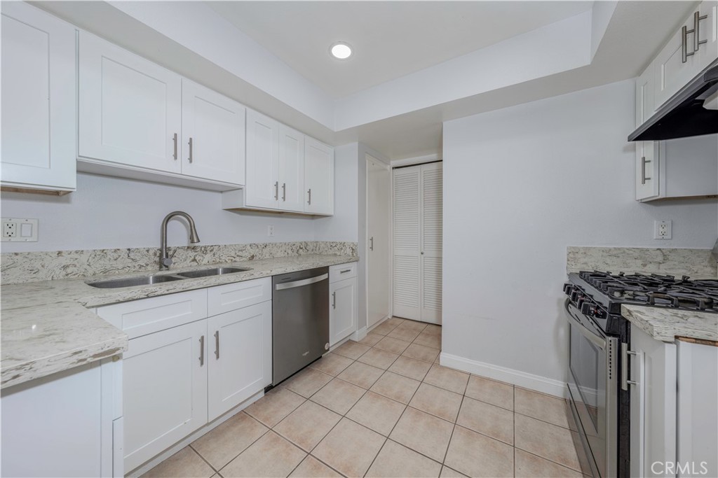 12660 Briarglen Loop, Unit G Stanton, CA 90680 - Photo 9 of 38 a kitchen with granite countertop a sink stove and cabinets