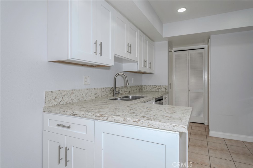 12660 Briarglen Loop, Unit G Stanton, CA 90680 - Photo 10 of 38 a kitchen with granite countertop white cabinets and a sink