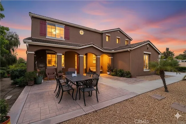 a view of a house with a chairs and table in a patio