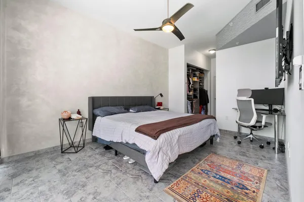 a bedroom with a bed tv and a window