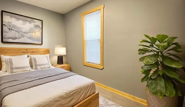 a bedroom with a bed and a painting on the wall