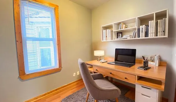 a view of a workspace with furniture and a window