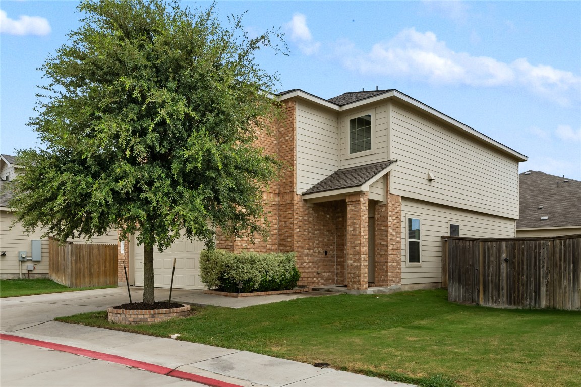 a front view of a house with a yard and trees