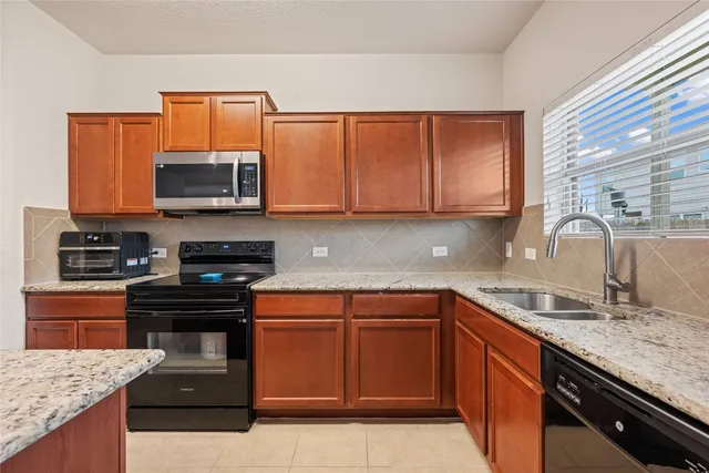 a kitchen with stainless steel appliances granite countertop a sink stove and microwave